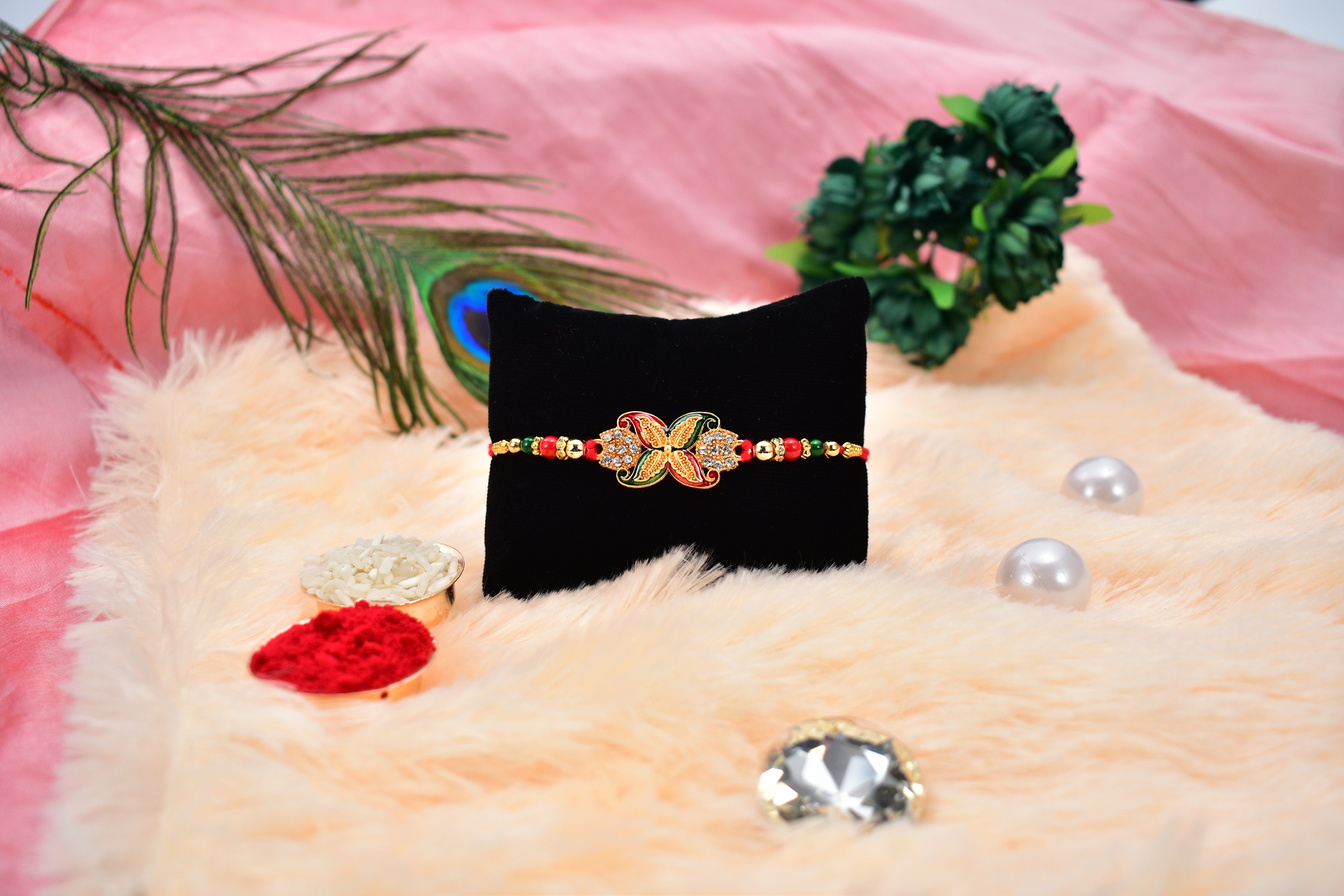 Elegant Red-green Bead Rakhi With Intricate Golden Flower Motif Elegant Red-green Bead Rakhi With Intricate Golden Flower Motif